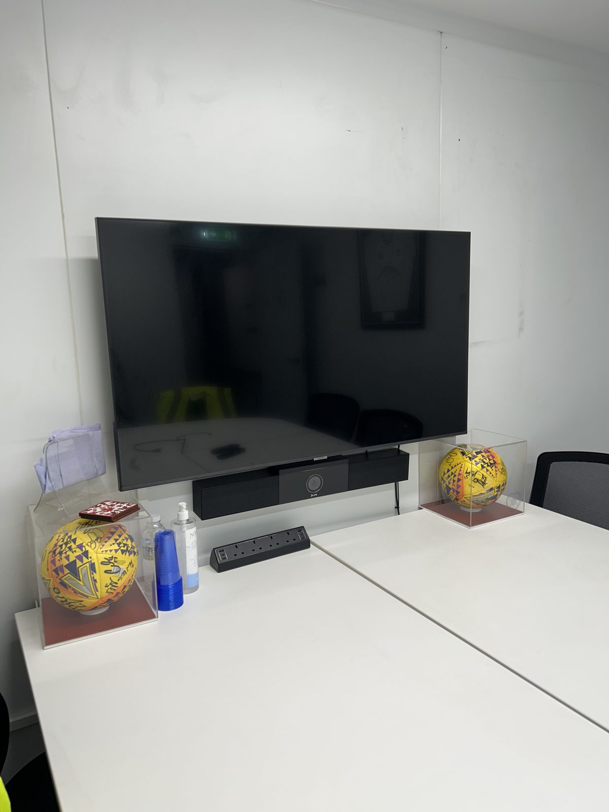 Meeting room with a wall-mounted TV and Poly video bar installed underneath