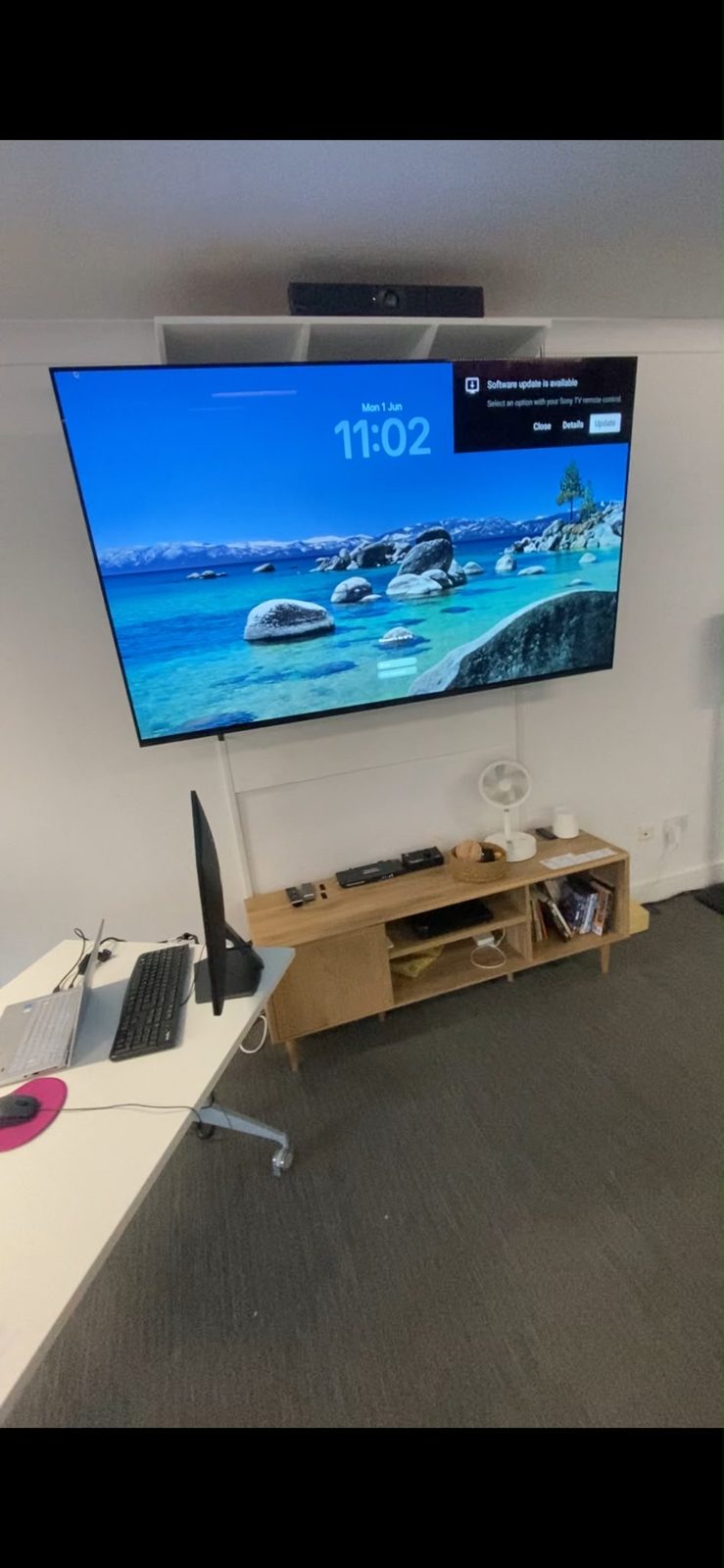Third meeting room with a wall-mounted TV and Poly video bar mounted above shelving